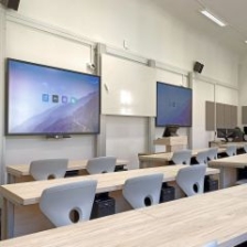 Počítačová učebna se dvěma dotykovými LCD displeji a studentskými stoly s elektrickými výsuvy PC
